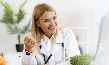 Arkansas family nurse practitioner smiling with pediatric patient during appointment